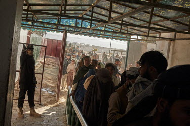 A Pakistani border guard controls crowds of Afghans returning from Pakistan at the border crossing in Spin Boldak. Between three and four thousand Afghans cross this border every day in the hope of mo...