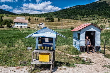 Serbian homes on the Kupres Plateau. A cheesemaker has a small stall to sell his produce next to the highway.