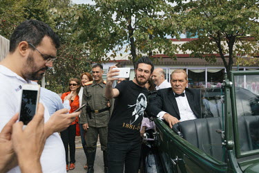Mustafa Kemal Ataturk lookalike Goksal Kaya, (centre right, seated in car) has many fans asking for photos and selfies before the start of the Turkish Victory Day motorcade.