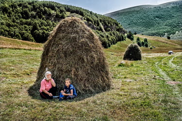 A woman and her son have lunch during haymaking near Lukomir. Lukomir is a highland village in Bosnia Herzegovina, the highest and most isolated permanent settlement in the country. It is home to 17 f...