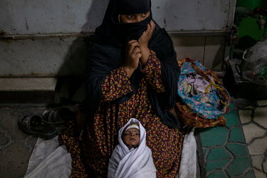 A woman begs with her baby in Shahr-e Naw.