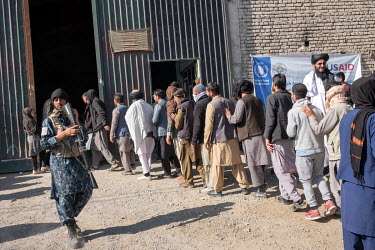 Taliban on security duty during a distribution of cash by the World Food Program to the poorest people at a former gymnasium.