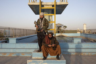 Taliban pose at the foot of the diving board of a disused swimming pool atop Wazir Akbar Khan hill.