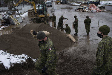 Canadian soldiers fill and lay sandbags as they prepare flood barriers following unprecedented rainfall on 14 November 2021 which triggered landslides and devastating flooding throughout the province,...