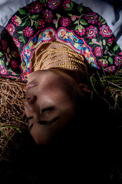 Fernanda Quimbiamba (27), a young Karanki woman sunbathing during a hike in the mountains. She left her father's flower farm to start a life in harmony with her identity and her territory. For her, th...