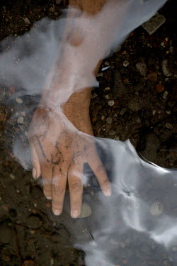 The hand of Lizet Tuquerres, a 15-year-old Karanki woman, submerged in the waters of the 'Las Tres Cascadas'.