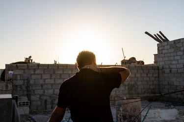 Mahmoud, a former Iraqi police officer from Baghdad, watching the birds fly around his rooftop, from his one room apartment in the Damascus suburb of Saida Zainab. He fled to Damascus, Syria, after be...