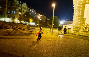 A boy, dressed in a costume, runs accross George of Podebrady Square, (Namesti Jiriho z Podebrad) during Halloween celebrations.
