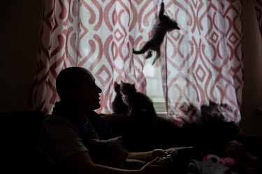 Wael watches TV at home whilst his recently born kittens climb on the curtains and sofa. He is an intersex trans man from Casablanca, Morocco, prays during the Islamic holy month of Ramadan. He now li...