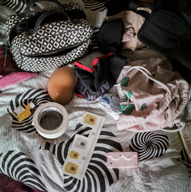 Shayma's breasts, lashes, clothes and some makeup on their bed at home, as they prepare before hosting a drag event at a popular queer night spot in Heidelberg Shayma is a Tunisian drag performer and...