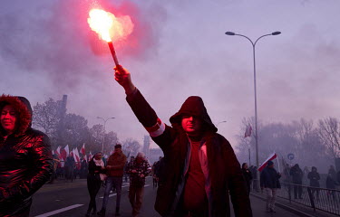 A man carries a burning flare during a far-right rally on National Independence Day.