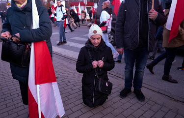 A woman kneels to pray during a far-right rally on National Independence Day.
