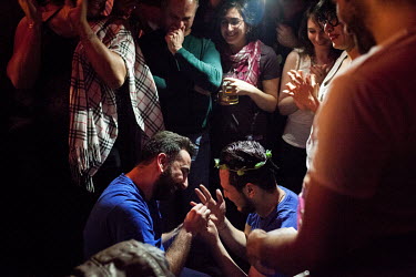 Nader (left) puts a ring on Omar's (right) finger after he accepted Nader's marriage proposal during Omar's birthday party. Both men are Syrian, and have lived in Istanbul for several years, whilst tr...