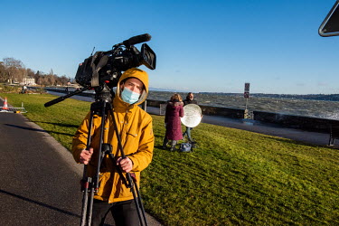 A news cameraman walks alongside Lake Geneva outside the President Wilson Hotel where talks were due to take place between American and Russian foreign ministers in an attempt to reduce the tensions o...