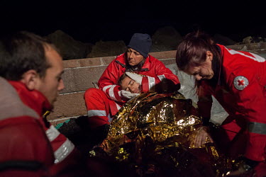 The Hellenic Red Cross treat an Afghan man in Molyvos harbour after the boat he was using to enter Greece from Turkey had engine trouble, and he spent three hours in the sea enduring cold temperatures...