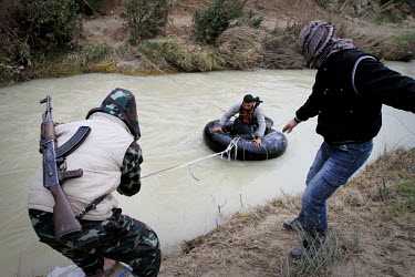Members of the Free Syrian Army move weapons, medicine and personnel across a river near Al Janoudiyah, Idlib province.