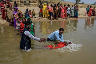 Local pastors baptise villagers on the banks of a river in Imamgunj district.