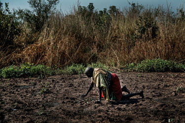 An old lady working in her field after returning from refugee camps in Uganda.
