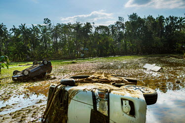 Overturned cars lie strewn about in a rice paddy in the aftermath of Typhoon Rai.