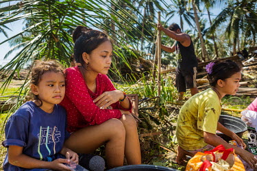 (L-R) Jyrah Mae Villamor (6), Arianne Villamor (16) and Rhian Gil Pacatang (12), all from Valladolid, the hardest hit area in Loboc, wash clothes and relax near where their houses once stood before a...
