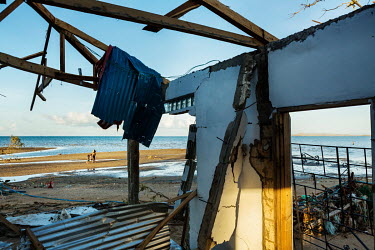 A family seen from a typhoon-wrecked house in Barangay Tapon heading along the beach from Achila Barangay, further down the coast, towards Ubay to source water in the aftermath of typhoon Rai.  The im...