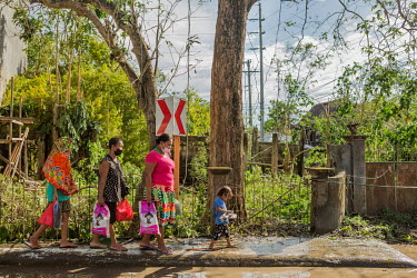 Members of the sea gipsy Bajdao (Bajau) tribe walk from a shelter towards their home after typhoon Rai.