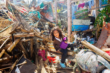 A young girl scales rubble and debris in Barangay Fatima in the aftermath of typhoon Rai.  The impact in this area was immense. Almost all of the houses in this district (purok) were completely destro...