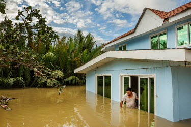 Garry Belacho (46) stands in a doorway of his house, in deep flood water, in the aftermath of typhoon Rai.
