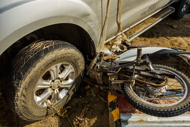 A motorbike lies crushed under a pickup truck following severe and sudden flooding caused by typhoon Rai.
