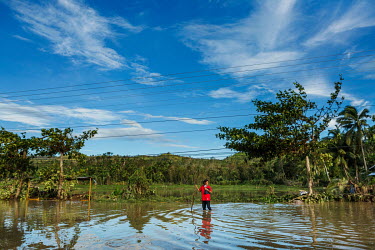 A woman wades through flood water in the aftermath of typhoon Rai.