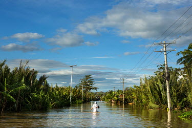 A man wades along a flooded road in the aftermath of typhoon Rai.