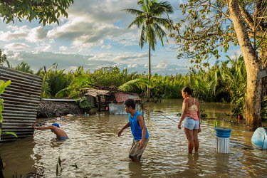 A family try to salvage possessions from their flooded home in the aftermath of typhoon Rai.