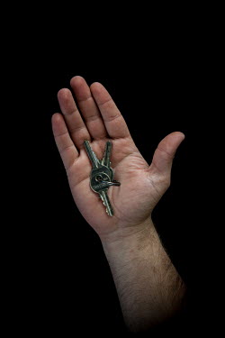 Khaled, 26, holds the keys to his home in Taybit al-Imam (Taybat al-Imam), Hama, 1 year 2 months after he fled Syria. He says he misses "warmth of life".  Syrian Nakba, Keys of home. The front-door ke...