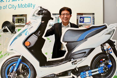 Wu Chih-I with an advert for a self-stabilising scooter, designed by the Industrial Technology Research Institute (ITRI) at the ITRI HQ.