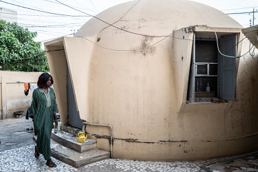 A woman outside a 'bubble' or Airform house, designed by Wallace Neff and built in the 1950s, in the districts of Point E and Zone B.