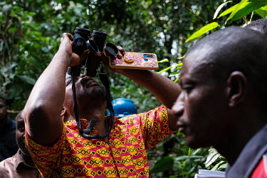 A participant learning to use binoculars during a wood biology workshop in the forest at the Yangambi research station.