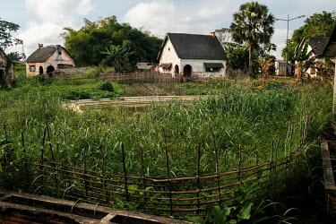 A ruined children's paddling pool and holiday chalets along the Congo River on the grounds of the Yangambi research station, built for colonial researchers.