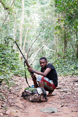 Souverain Afefela Baso posing with he and his hunting partner's kills near a bushmeat market at a crossroads of forest tracks in Yangambi. He and his hunting partner estimate they will earn about 30US...