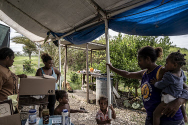 Families living in slum housing unpack food boxes from Action Solidaire including packages of products close to their expiry date donated by supermarkets. There are over 64 slum areas in New Caledonia...