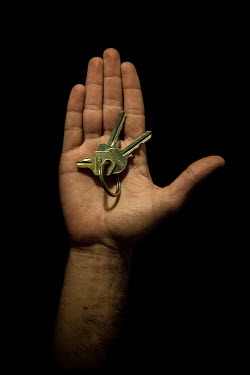 Nader, 25, with the keys to his home in Homs that he fled 2 years, 10 months previously. He describes his home as "shelter, warmth, happiness".  Syrian Nakba, Keys of home. The front-door keys to t...