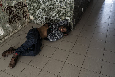 A young man lies on the ground at the dilapidated Magenta housing estate where a group of youths have gathered to smoke cannabis.