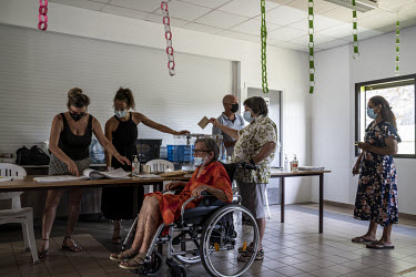 People queue up to vote in the 2021 independence referendum in an affluent area of Noumea popular with people of European ancestry.