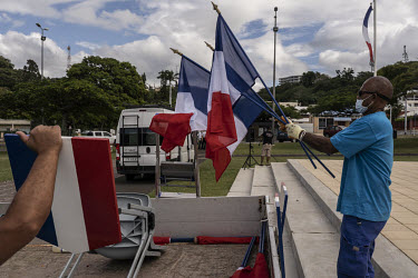 Workers dismantle French tricolour flags and displays after Patrice Faure, High Commissioner to the Republic of France in New Caledonia, presided over a ceremony to commemorate the dead in the Algeria...