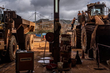 Mechanics work on mining vehicles in a garage at the Prony Resources Nickel Mine.