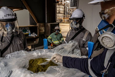 A plant worker takes a sample of processed nickel before the bag is sealed and shipped worldwide via container, at the Prony Resources nickel mine plant.