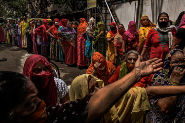 Sex workers wait in queue to recevie a free food rations package being distributed by Bharatiya Janata Party (BJP) workers during a lockdown imposed as a preventive measure to curb the spread of COVID...