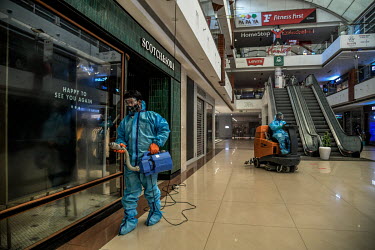 Workers deep clean a shopping centre prior to its re-opening following the relaxation of the COVID-19 lockdown.
