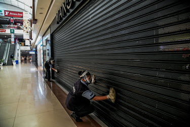 Workers deep clean a shopping centre prior to its re-opening following the relaxation of the COVID-19 lockdown.