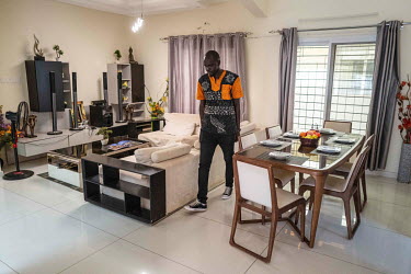A salesman walks through the living room of a show house in Senegindia's SD City residential and commercial complex in Diamniadio, a new city being built near Dakar.
