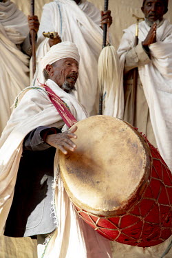 An elderly man plays a large drum during religious celebrations at Lalibela